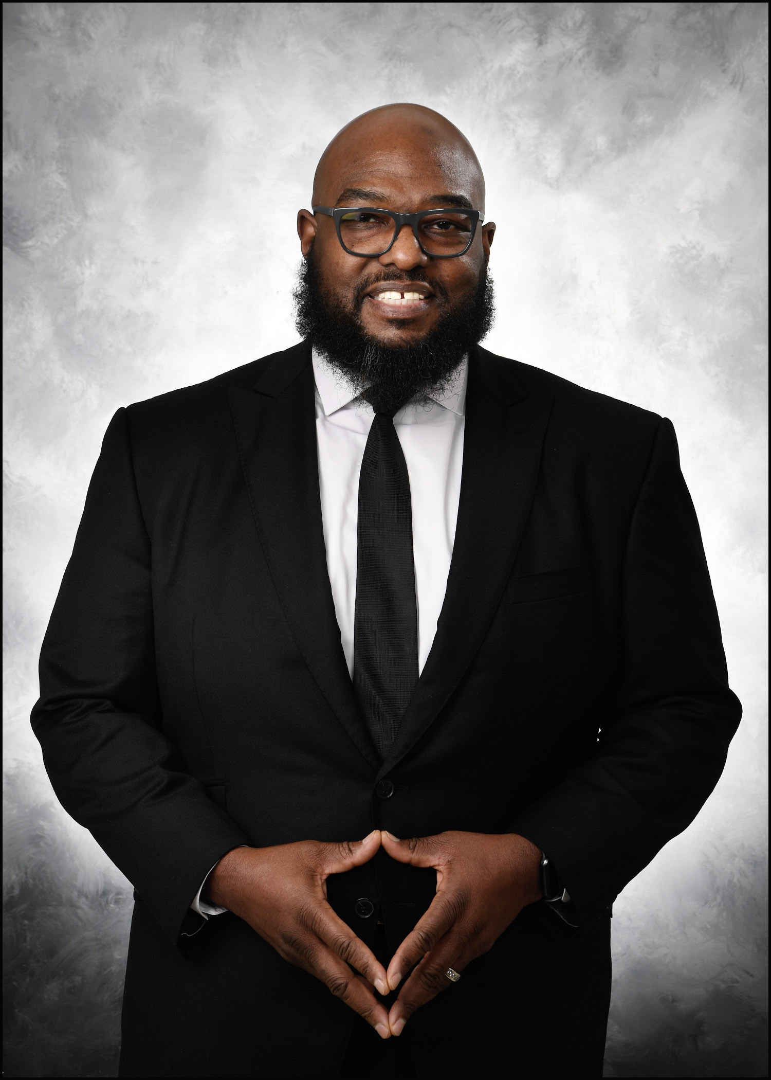 Formal portrait of Dr. Corey J. Henderson in a black suit and tie